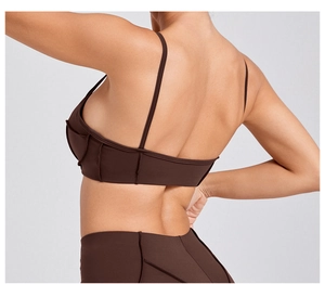 Detail view of brown yoga sports bra with thin straps and decorative stitching