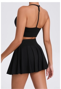 Detail view of black athletic tennis set featuring racerback top and pleated mini skirt