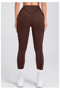 Dettaglio dei leggings marroni a vita alta con cucitura a V posteriore per effetto push-up