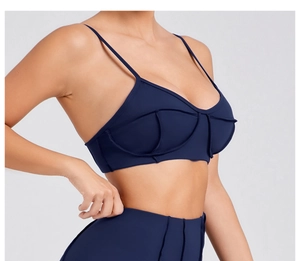 Detailed side view of navy blue sports top with thin straps and textured seams