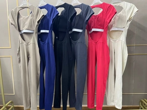 Selection of quick-dry open-back yoga jumpsuits in various colors on golden hangers