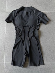 Détail d'une combinaison de yoga noire à manches courtes avec coutures décoratives et coussinets