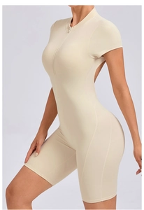 Detail of light beige athletic bodysuit showing front zipper and ergonomic seam lines