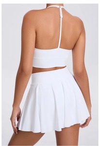 Rear view of white halter neck sports top and high waisted pleated skirt for tennis and fitness