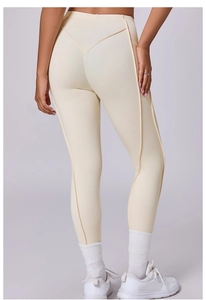 Dettaglio dei leggings da yoga color crema a vita alta con cuciture modellanti speciali