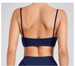 Macro view of navy blue sports bra showing thin straps and low open back design