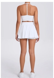 Rear view of white racerback sports bra and pleated tennis skirt set on a model
