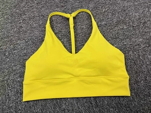 Flat lay of bright yellow sports bra with thin straps and supportive wide band