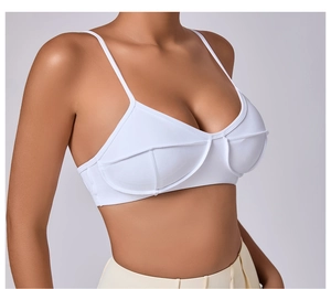 Detail view of white yoga sports bra showing structured seam lines and thin straps