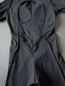 Détail du dos en V d'un body de sport noir avec des coutures de renfort