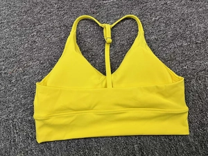 Close-up of bright yellow sports bra with adjustable straps and silver buckle detail