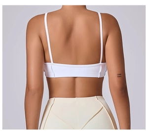 Detailed back view of white sports bra with thin straps and open back design