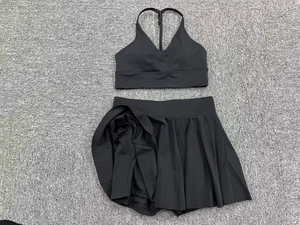 Close-up of black two-piece tennis set with V-neck sports bra and pleated athletic skirt