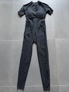 Détail d'un une-pièce de sport noir avec coutures apparentes et lignes sculptantes
