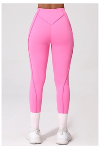 Dettaglio di leggings yoga rosa acceso a vita alta con cucitura a V ed effetto push-up
