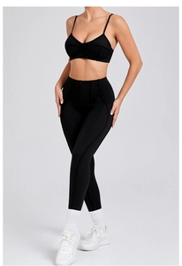 Detail van zwarte yoga-set met sport-bh met dunne bandjes en legging met hoge tailleband