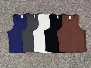 Cinque top sportivi elasticizzati in vari colori disposti su un tappeto a trama spessa