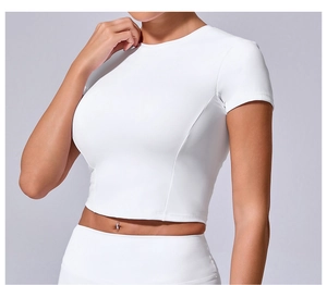 Detail view of a white slim-fit crop top showing seamless stitching and premium elastic fabric