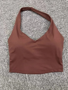 Soutien-gorge de sport marron à licou et col en V posé à plat sur un tapis gris