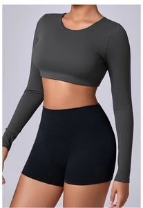 Detail of grey cropped long-sleeve gym top and high-waisted shorts on a model