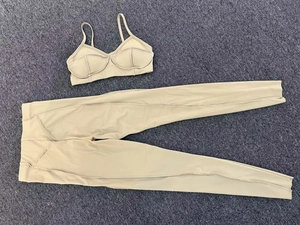 Detail van kaki fitnessset met versterkte stiksels op de sportbeha en de yoga-leggings