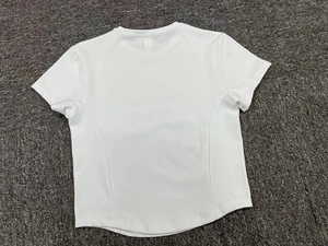 Detail view of the moisture-wicking white yoga T-shirt with a curved back hemline