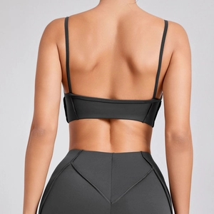 Women's charcoal grey athletic set featuring a strappy sports bra and high-waisted leggings