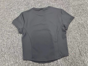 Detail view of the slim-fit charcoal grey short sleeve yoga top with curved back hem