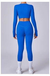 Vista trasera del conjunto de yoga azul con top de manga larga, agujeros para el pulgar y mallas