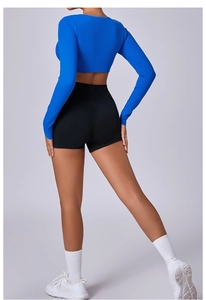 Detail of blue long-sleeved crop top and high-waist shorts for fitness and yoga