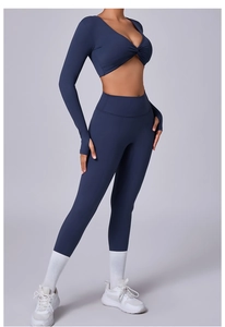 Detalle del conjunto de yoga azul marino con top corto de manga larga anudado y leggings altos