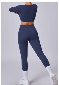 Vista trasera del conjunto de yoga azul oscuro con top corto de manga larga y leggings