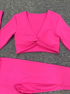 Conjunto de yoga rosa intenso con top corto de manga larga y cuello en V y mallas altas