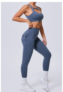 Détail du legging taille haute avec poche latérale et brassière de sport ajourée bleu gris