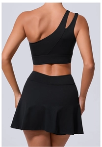 Détail du soutien-gorge de sport noir à une épaule et texture du dos de la jupe