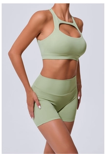 Détail d'un ensemble de yoga vert sauge avec brassière découpée et short à taille haute