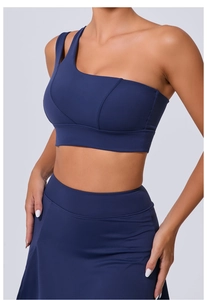 Détail de la brassière de sport asymétrique bleu marine et de la jupe taille haute