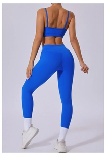 Detail of blue yoga set featuring a cross-back sports bra and high-waisted leggings