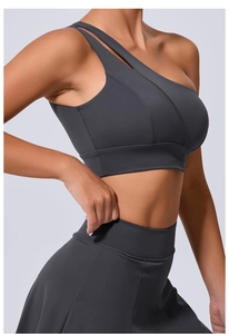 Détail de la brassière de sport gris anthracite à une épaule et bretelles découpées
