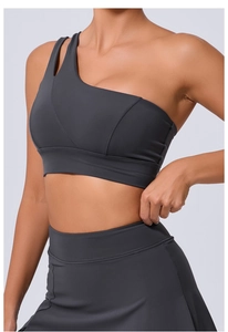Détail du soutien-gorge de sport asymétrique gris foncé avec découpe sur la bretelle