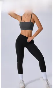 Détail de la brassière de sport gris anthracite et du legging de yoga noir sur modèle