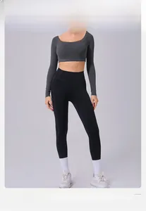 Detail view of dark grey long sleeve crop top and black yoga pants on model