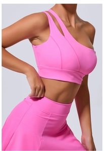 Détail d'un soutien-gorge de yoga rose asymétrique avec bretelle unique et découpe