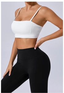Détail du soutien-gorge de sport blanc et du pantalon de yoga noir à taille haute