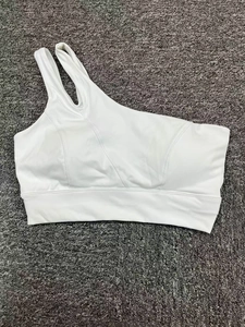 Détail d'une brassière de sport blanche à une épaule avec découpe et ourlet large