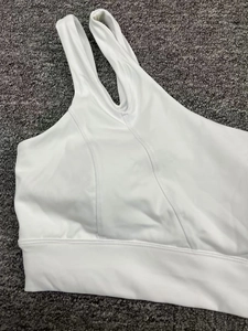 Gros plan des larges bretelles de la brassière de sport blanche en tissu élastique