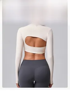 Détail de la découpe ovale dans le dos du haut de yoga blanc et du legging gris foncé