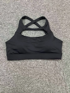 Détail de brassière yoga noire avec découpe et bretelles croisées sur tapis texturé