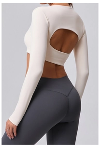 Détail d'un haut de yoga dos nu crème et d'un legging de compression gris taille haute