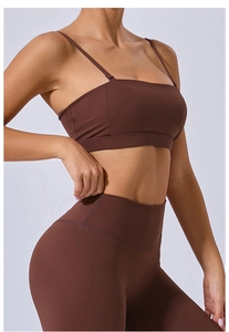 Détail du pantalon de yoga taille haute marron foncé et brassière de sport à fines brides